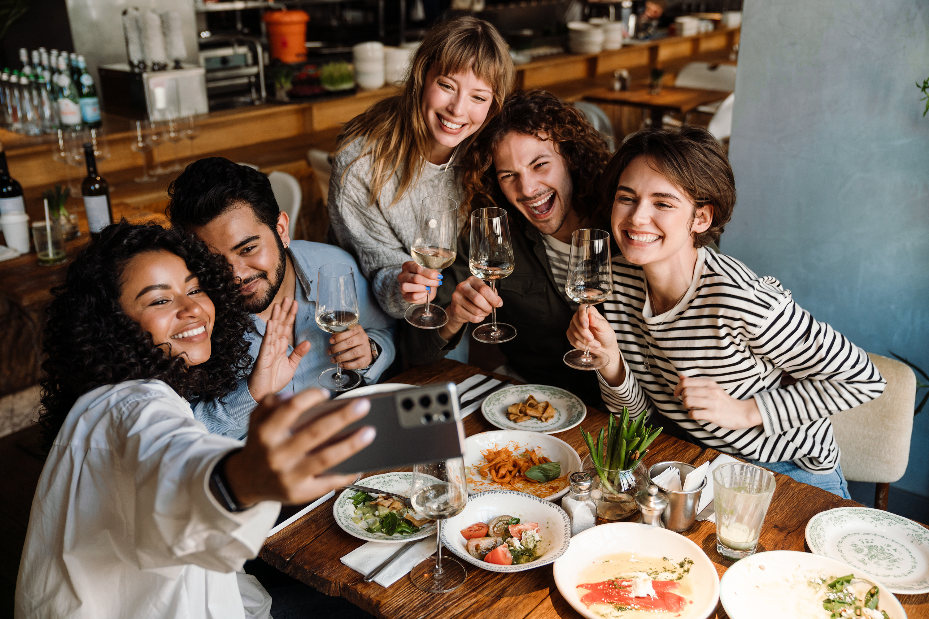 Group of cheerful friends taking a selfie at a restaurant